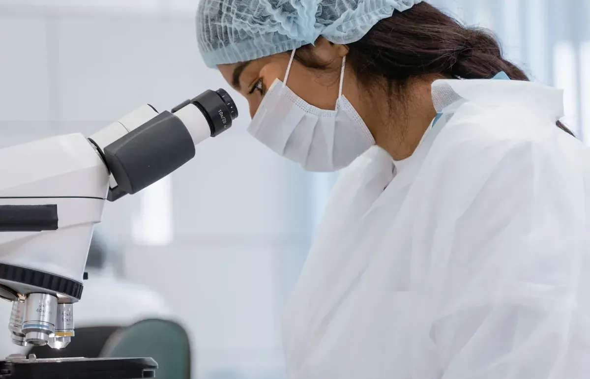 Medical laboratory professional using a microscope in a diagnostic laboratory