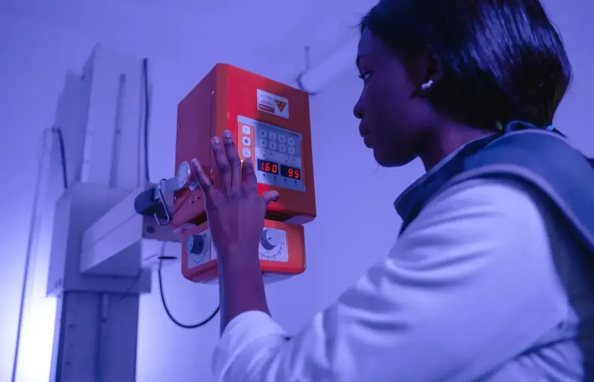 Radiography professional operating X-ray equipment in a clinical imaging room